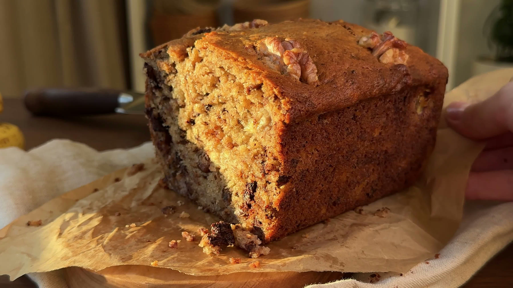 Walnut banana bread held in warm natural kitchen light