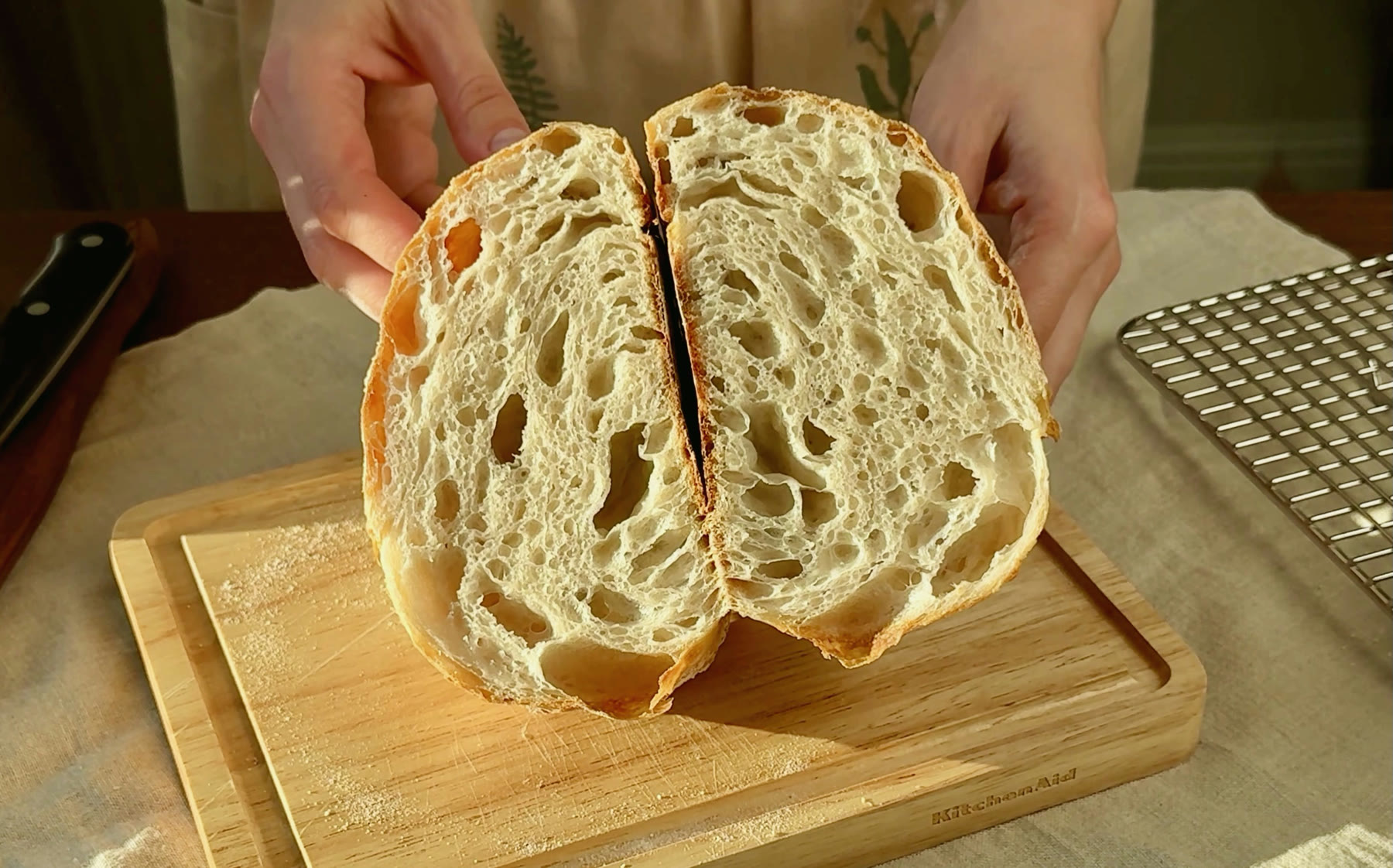 Open crumb of an overnight yeast bread held over a wooden board